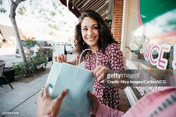 woman looking into gift bag - geschenktüte einwickelpapier stock-fotos und bilder
