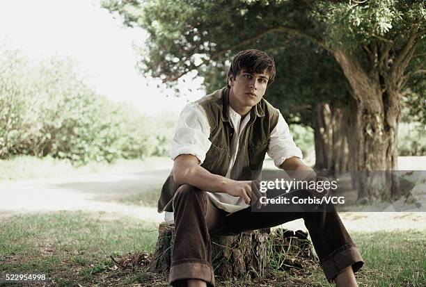 young man sitting on tree stump - baumstumpf stock-fotos und bilder