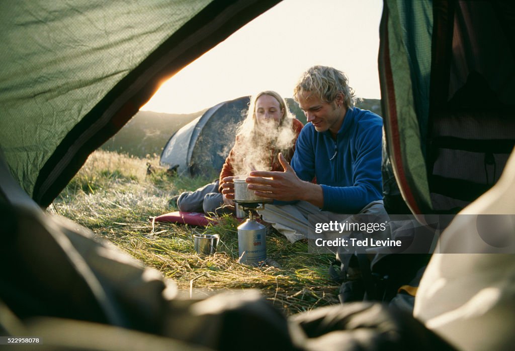 Couple Boiling Water Outside Tent