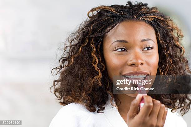 woman applying lipstick - applying lipstick ストックフォトと画像