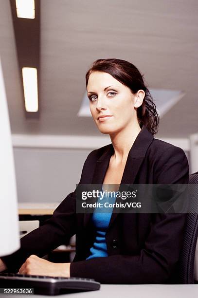 brunette businesswoman at her desk - lapel 個照片及圖片檔