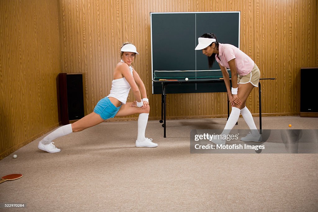 Young Women Stretching by Table Tennis Table