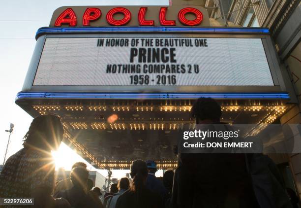 People gather outside the Apollo Theater to listen to music by Prince April 21, 2016 in New York. - Emergency personnel tried and failed to revive...