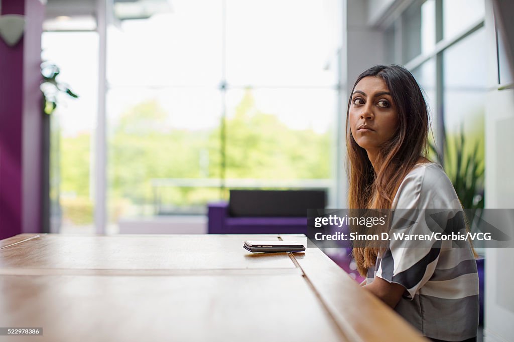 Woman sitting at table with smart phone