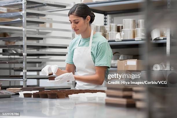 worker in manufacture of chocolates - chocolatier photos et images de collection