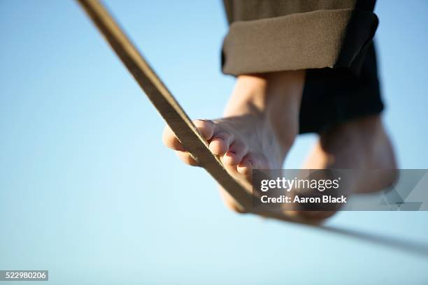 woman slacklining in bare feet - tightrope stockfoto's en -beelden