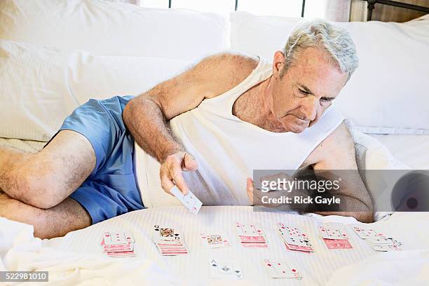 man playing cards on bed - boxer vintage stockfoto's en -beelden