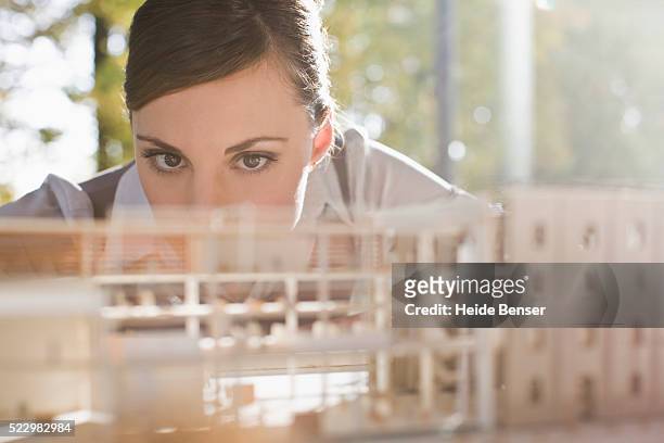 businesswoman examining architectural model - architekturmodell stock-fotos und bilder