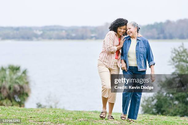 mother and daughter walking outdoors - mother and daughter hugging stock pictures, royalty-free photos & images