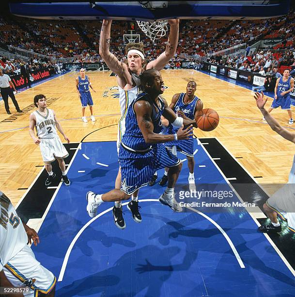 Steve Francis of the Orlando Magic takes the ball to the basket against Chris Andersen of the New Orleans Hornets during the game at TD Waterhouse...