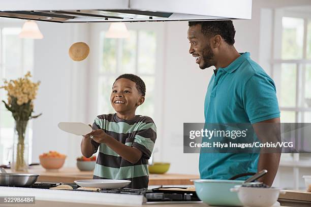 boy (10-12) tossing pancake while cooking - flipping pancake stock pictures, royalty-free photos & images