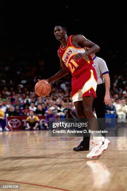 Dominique Wilkins of the Atlanta Hawks sets up a play against the Los Angeles Lakers circa 1991 during an NBA game at the Forum in Los Angeles,...