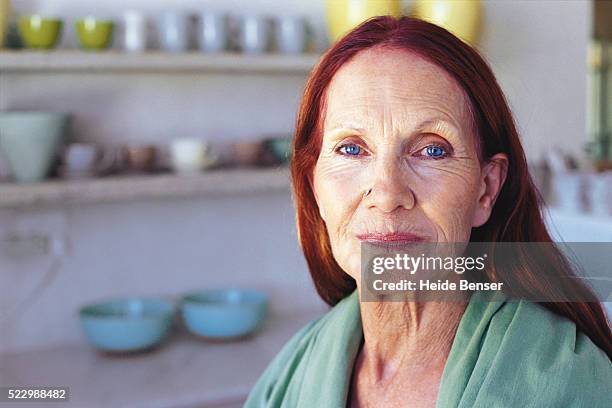 senior woman in kitchen - piercing stock-fotos und bilder