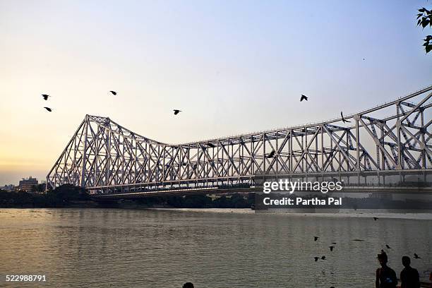 howrah bridge over river ganga at late evening - ponte howrah - fotografias e filmes do acervo
