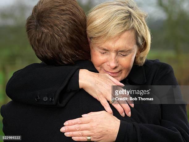 crying woman hugging man - mourning stock-fotos und bilder