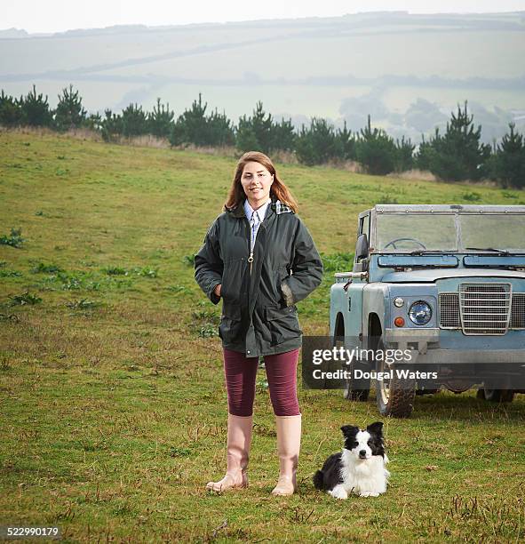 portait of female farmer with dog and vehicle. - autobauer stock-fotos und bilder