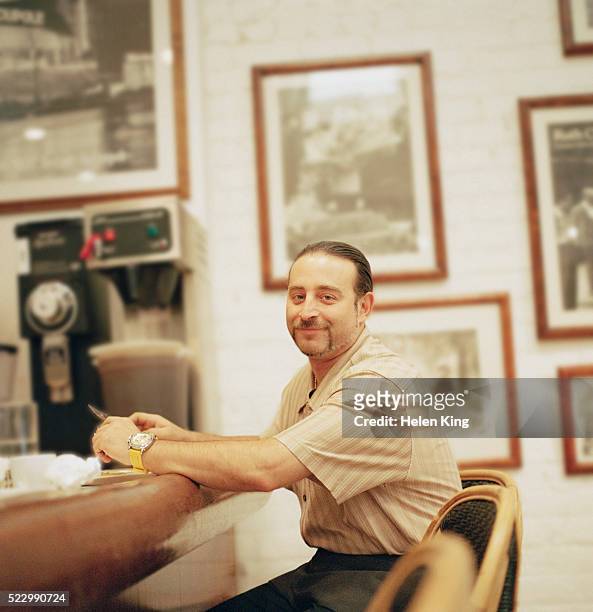 man sitting at the counter in a diner - man eating at diner counter foto e immagini stock