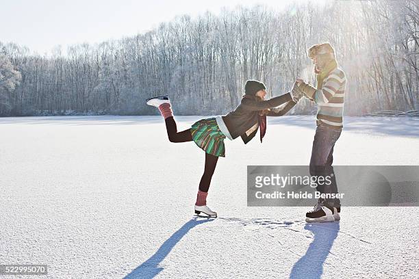 couple ice skating together - ice skate stock-fotos und bilder