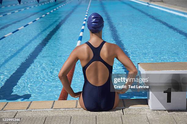 swimmer sitting at pool's edge - swim suit stock pictures, royalty-free photos & images