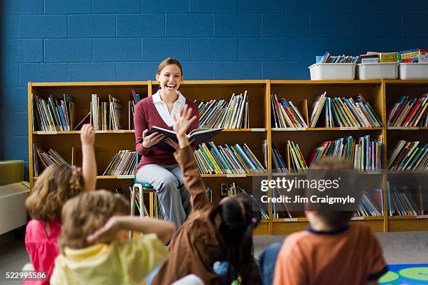 teacher reading to class - librarian stock-fotos und bilder