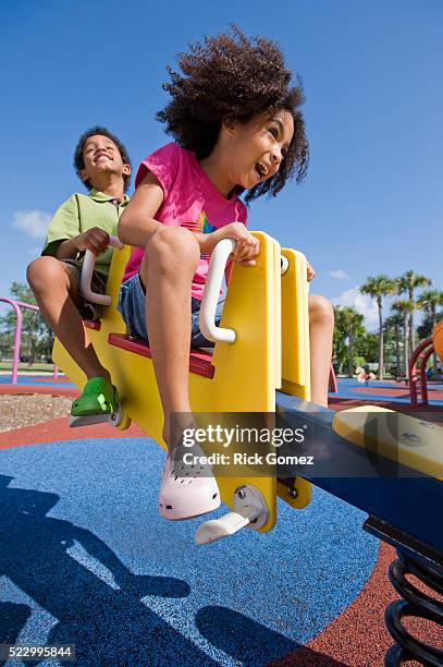 children playing on see saw - see saw fotografías e imágenes de stock