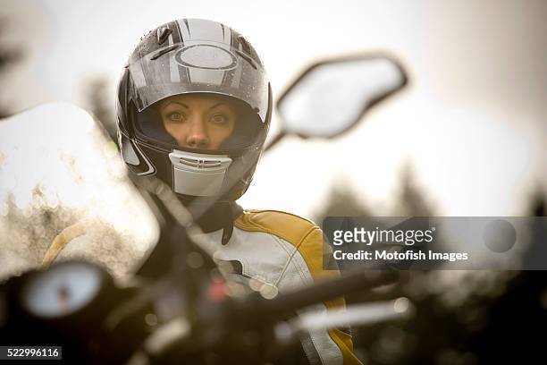 motorcycle rider standing in front of bike - woman motorcycle stock pictures, royalty-free photos & images