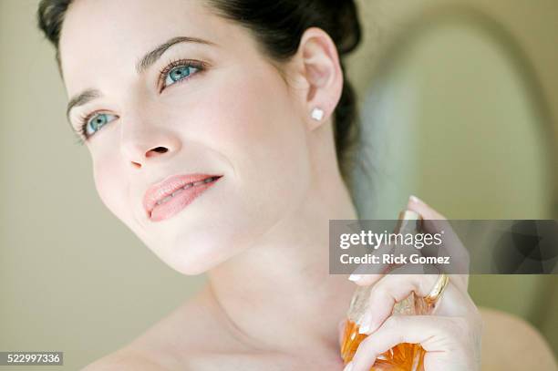 woman putting on perfume - perfume atomizer stock pictures, royalty-free photos & images