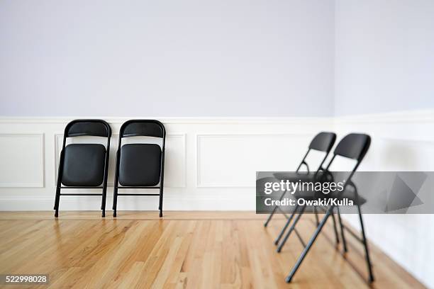 folding chairs along wall - folding chair stock pictures, royalty-free photos & images