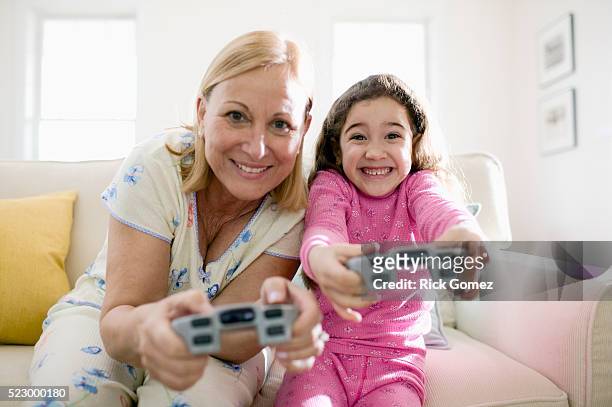 grandmother and granddaughter playing video game - game six stockfoto's en -beelden