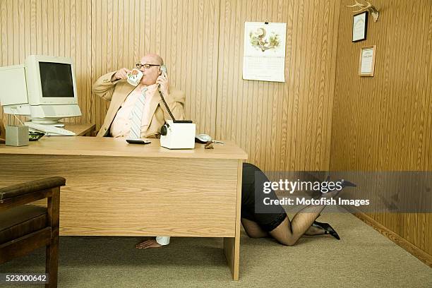 secretary crawling under businessman's desk - archival office stock pictures, royalty-free photos & images