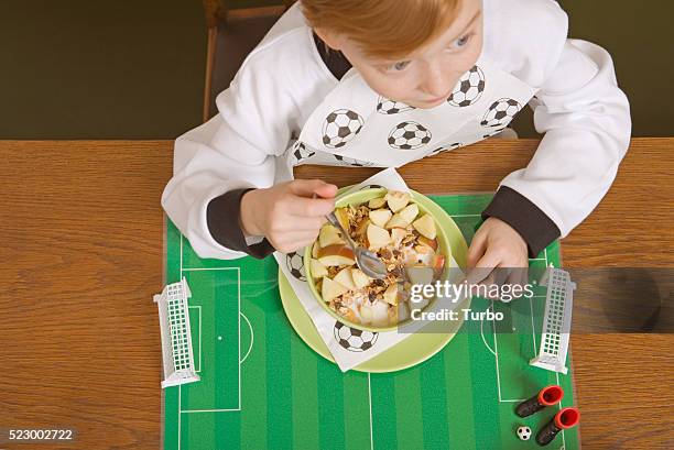 boy eating muesli on soccer field place mat - place mat stock pictures, royalty-free photos & images