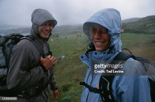 couple hiking in countryside - rain couple stockfoto's en -beelden