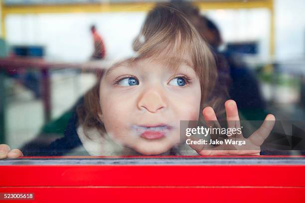 boy looking out window - kindergarten stock-fotos und bilder