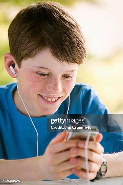boy listening to music on mp3 player - white mp3 player stock pictures, royalty-free photos & images