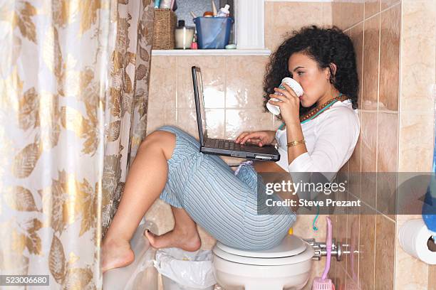 woman using laptop in bathroom - toilet laptop stock pictures, royalty-free photos & images