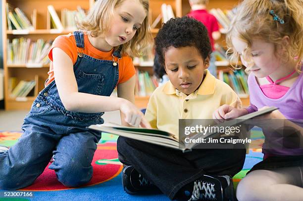 elementary students sharing book - sharing stories stock pictures, royalty-free photos & images