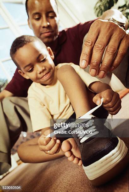 tying his shoelace - boy tying shoes stock-fotos und bilder