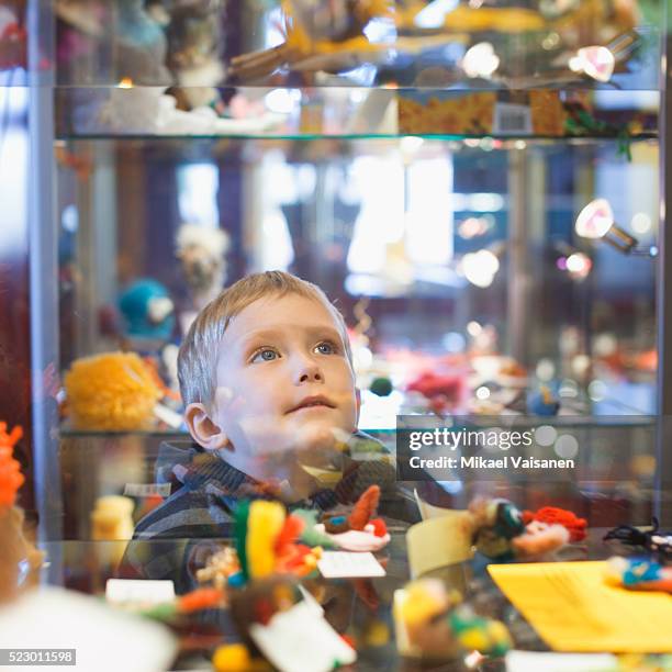 boy window shopping outside toy store - loja de brinquedos imagens e fotografias de stock