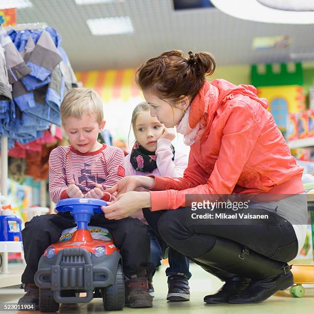 mother comforting son in department store - tantrum stock pictures, royalty-free photos & images