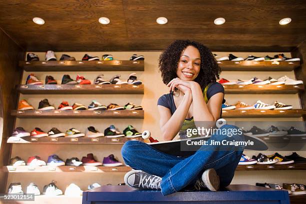 woman sitting in front of shoe display - sports equipment store stock pictures, royalty-free photos & images