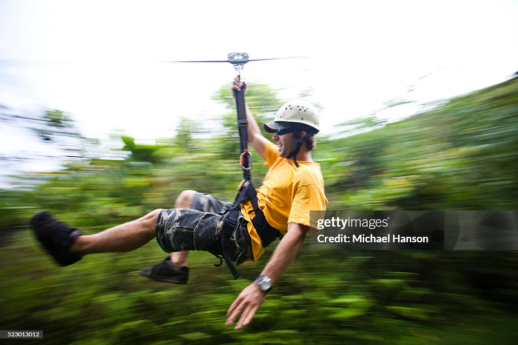 Young man riding a zip line
