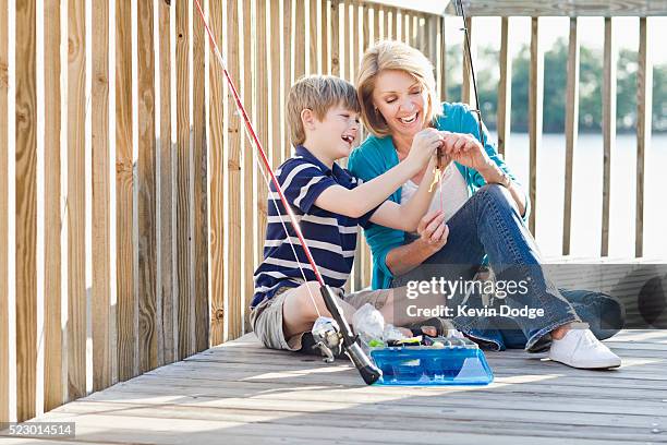 mother and son prepping fishing pole - vintage fishing lure stock pictures, royalty-free photos & images