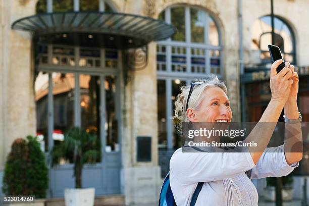 female tourist photographing architecture, carcassonne, france - tour france stock pictures, royalty-free photos & images