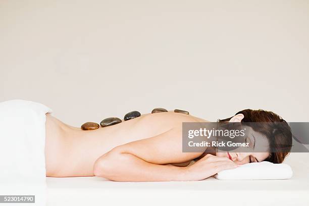 woman getting hot stone therapy - terapia lastone fotografías e imágenes de stock