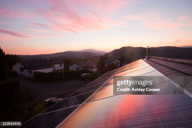 sunset over a house in ambleside, lake district uk, with a 3.8 kw solar panel system on the roof. - solar panels stock pictures, royalty-free photos & images