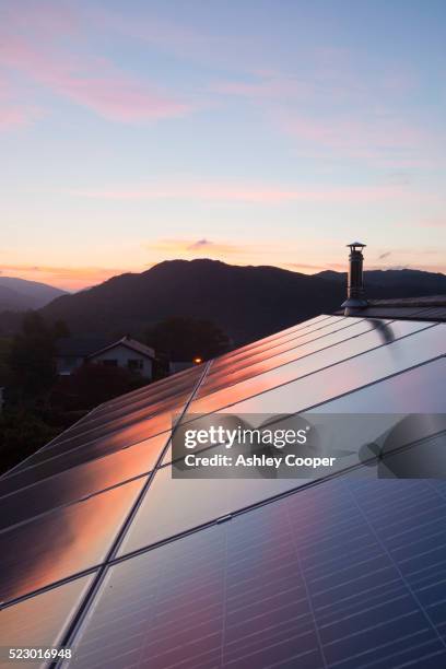 sunset over a house in ambleside, lake district uk, with a 3.8 kw solar panel system on the roof. - green footprint stock pictures, royalty-free photos & images