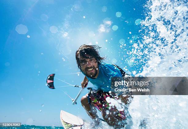 happy kitesurfer splashing - man surfing photos et images de collection