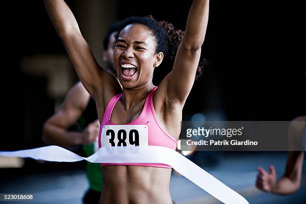 runner crossing the finish line - vincere foto e immagini stock