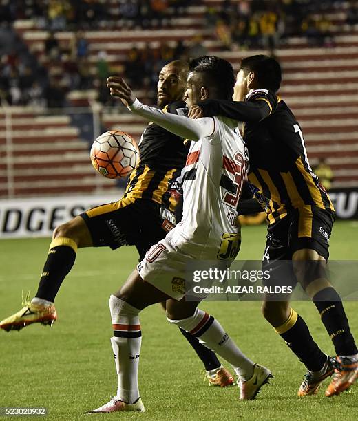 Kelvin of Brazil's Sao Paulo vies for the ball with Ernesto Cristaldo and Diego Wayar of Bolivia's The Strongest during their Copa Libertadores...