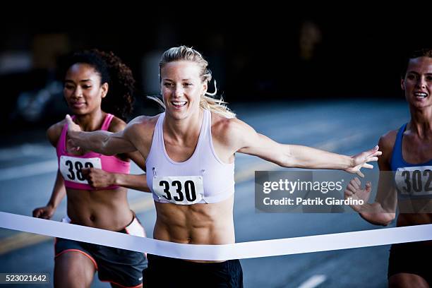 runner crossing the finish line - meta fotografías e imágenes de stock